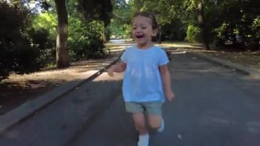 Little girl running outside in the park. Catch Me If You Can.