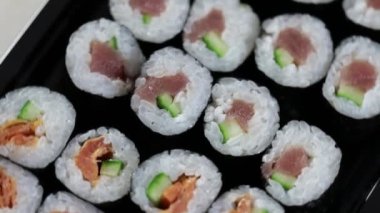 Sushi dürümlerini kapayın. Avokado, somon ve ton balıklı Japon yemeği..