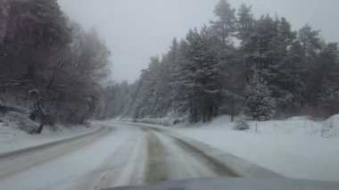 Driving winter snow road. View through the windshield on the highway in winter