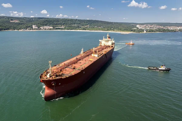 Aerial view of a red oil tanker leaves the port. Tanker ship logistic and transportation business oil and gas industry.
