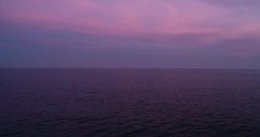 4k drone video uçuşu okyanus üzerinde, deniz güzel mor günbatımında. Suya yakın.