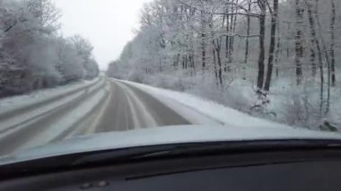 Kış karlı yolu sürüyorum. Kışın arabanın ön camından yola bak.