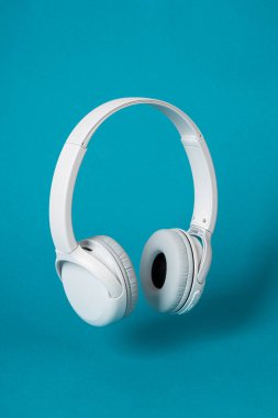 Mavi arka planda kablosuz beyaz kulaklık. Müzik konsepti. Mavi arka planda kulaklıklar. 
