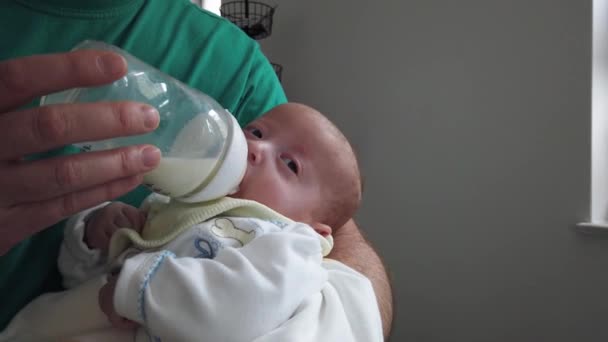 ミルクボトルから赤ん坊を抱っこし給餌する父 赤ん坊に餌をやる父親を閉めろ — ストック動画