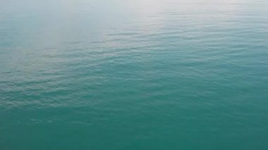 İnsansız hava aracı okyanus ve deniz üzerinde uçuyor. Suya yakın.