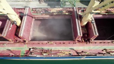 Limandaki vinçlerle kuru buğday kargo gemisi yükleniyor. Deniz kargo gemisinin ambarına hava görüntüsü yükleniyor