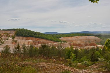 Manzara. Kum ocağı. Yeşil ağaçlar. Genç Noel ağaçları. Dağlar. Bulutlu gökyüzü