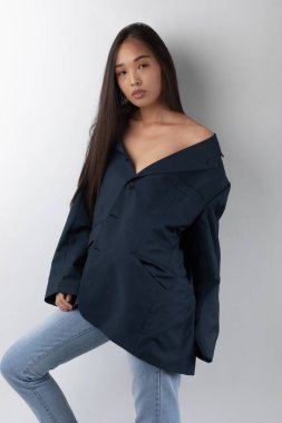 Beyaz arka planda poz veren ceketli çekici Asyalı kadın..