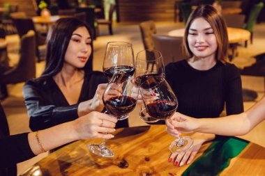 Çekici kızlar restoranda şarap içerler..
