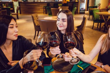 Çekici kızlar restoranda şarap içerler..