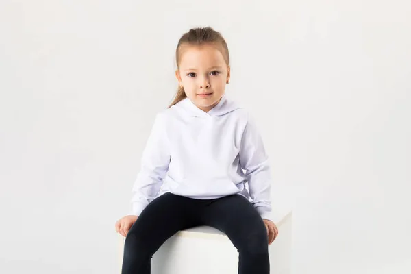 Dziewczyna Białej Bluzie Siedzi Białym Tle Bluzy Kapturem Dla Dzieci — Zdjęcie stockowe