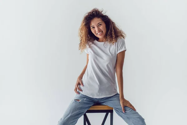 Mulher Sorridente Com Cabelos Cacheados Exuberantes Branco Shirt Senta Fundo — Fotografia de Stock