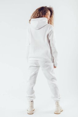 Woman with thick curly hair in a white suit from a hoodie and sweatpants back view. clipart
