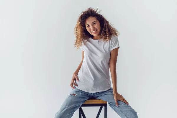 Glimlachende Vrouw Met Weelderig Krullend Haar Wit Blank Shirt Zit — Stockfoto