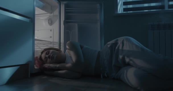U otevřené ledničky spí mladá žena.. — Stock video