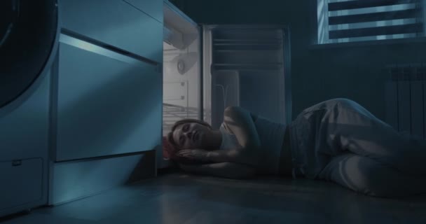 Młoda kobieta śpi przy otwartej lodówce. — Wideo stockowe