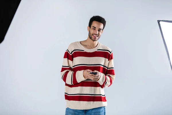 Young African American Man Smartphone His Hands Stands White Background — Stock Photo, Image