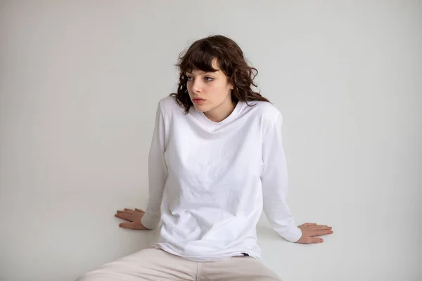 Ung Kvinna Med Lockigt Hår Vit Långärmad Shirt Sitter Vit — Stockfoto
