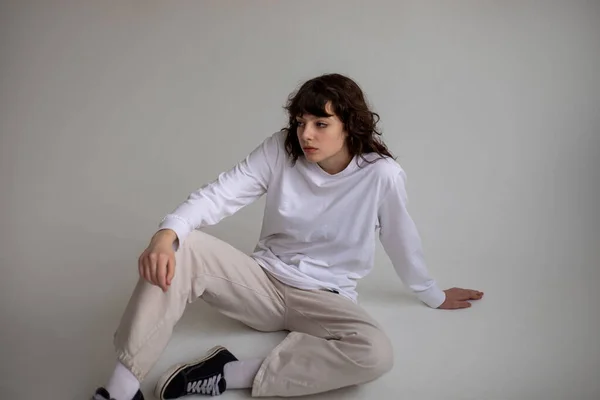 Jovem Com Cabelo Encaracolado Uma Camiseta Branca Manga Comprida Senta — Fotografia de Stock