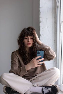 Kıvırcık saçlı çekici genç kadın selfie çekiyor..