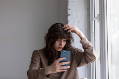 Kıvırcık saçlı çekici genç kadın selfie çekiyor..