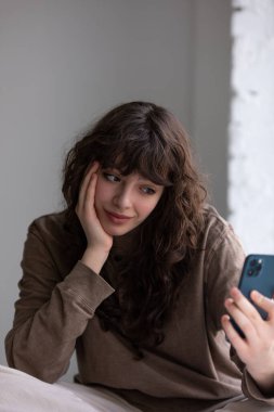 Kıvırcık saçlı çekici genç kadın selfie çekiyor..