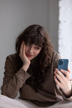 Kıvırcık saçlı çekici genç kadın selfie çekiyor..