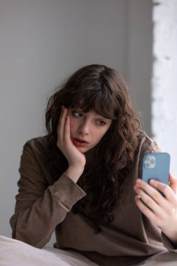 Kıvırcık saçlı çekici genç kadın selfie çekiyor..