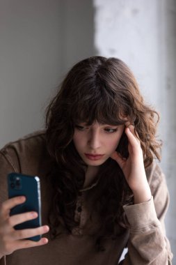 Kıvırcık saçlı çekici genç kadın selfie çekiyor..