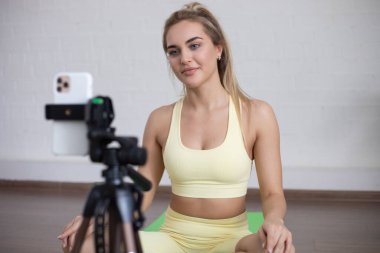 Akıllı telefondan evde canlı yayın yapmak için spor blogcusu video kaydı yapıyor.