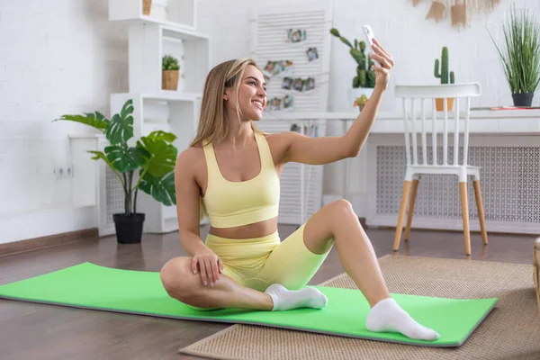 Mujer Tomando Una Selfie Mientras Está Sentada Una Esterilla Yoga — Foto de Stock