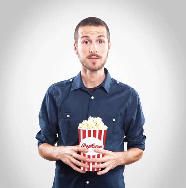 Mladý muž, sledovat film s popcorn — Stock fotografie