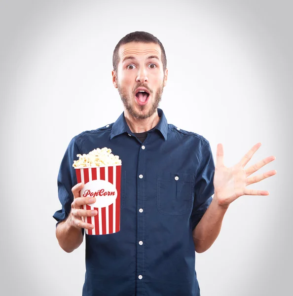 Junger Mann schaut einen Film mit Popcorn — Stockfoto