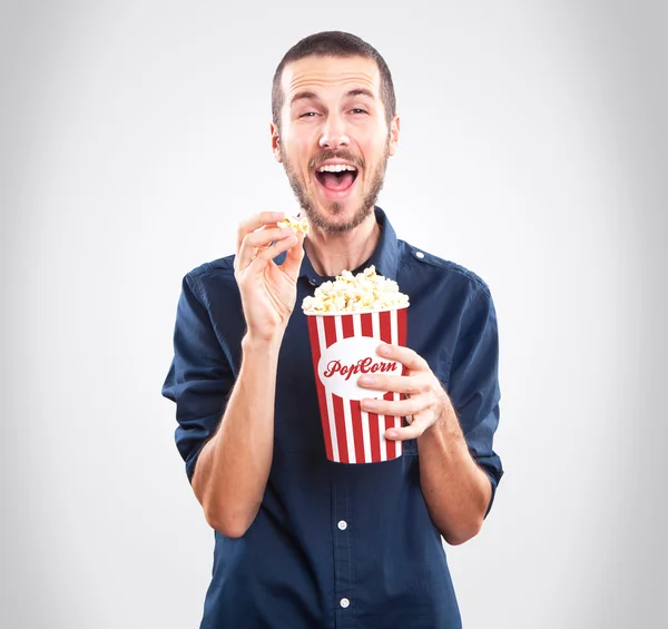 Jovem homem feliz assistindo filme e segurando pipocas — Fotografia de Stock