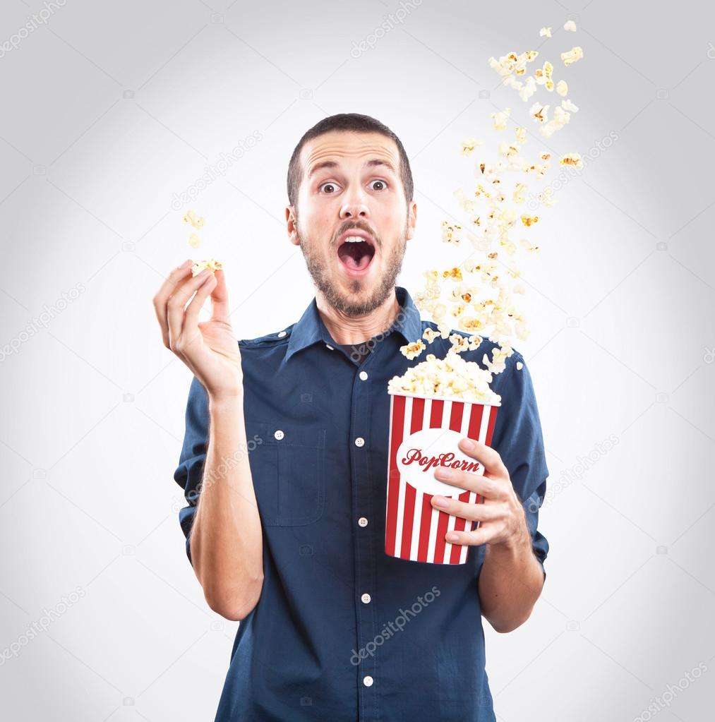 Young man watching a movie with popcorn