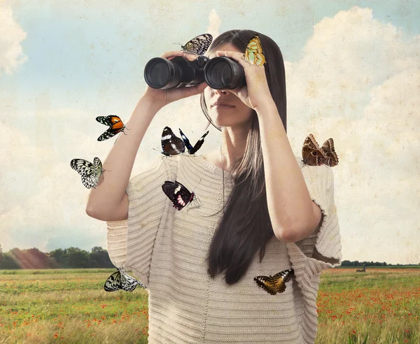Mujer joven mirando con binocular con mariposas Imágenes De Stock Sin Royalties Gratis
