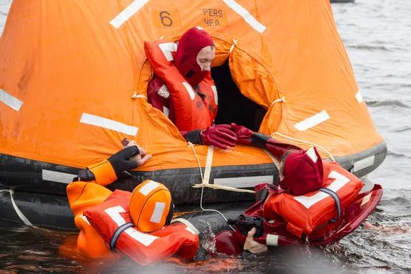 denizcilerin yatılı içine kurtarma botu tarafından hayatlarını kurtarmak deneyin..