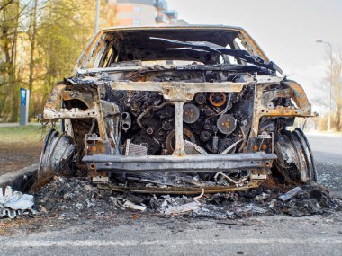 Gün boyunca caddede yanan arabaya alçak açılı ön görüş sağla. Yanmış motora seçmeli odaklan.