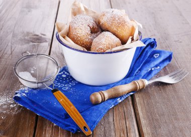 rustik ahşap zemin üzerinde metal bir rustik kase tarçın çörek ile elek pudra şekeri