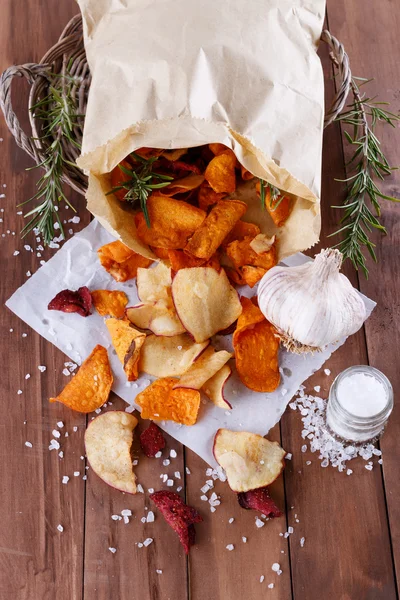 Gezonde plantaardige chips op papier met zeezout, rozemarijn en knoflook Rechtenvrije Stockafbeeldingen