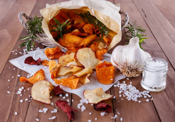 Healthy vegetable chips on paper with sea salt, rosemary and garlic — Stock Photo, Image
