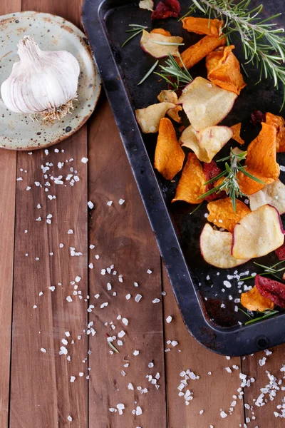 Healthy vegetable chips with sea salt, rosemary and garlic on a metal tray on a rustic background — Stock Photo, Image