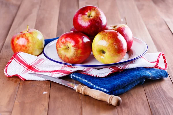 Rode biologische appels in een metalen plaat op houten achtergrond — Stockfoto