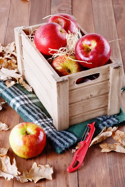 Red organic apples in a wooden crate on wooden background — Stock Photo, Image