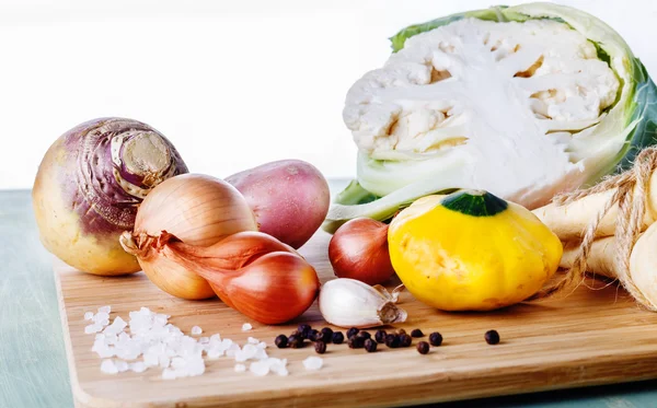 Organic vegetables on chopping board on wooden background — Stock Photo, Image