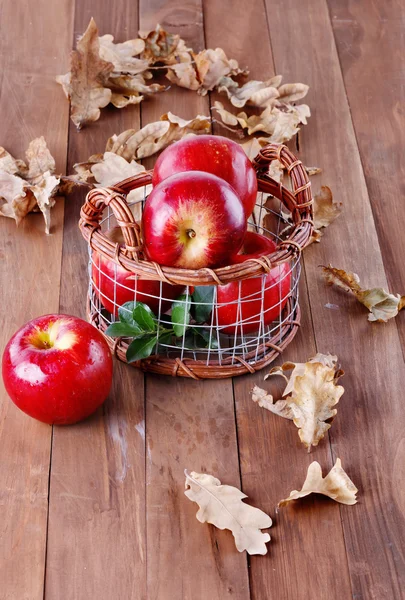 Red organic apples in a metal basket on wooden background — Stock Photo, Image