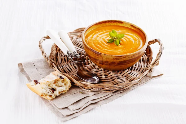 Soupe de citrouille avec pain sur nappe blanche — Photo