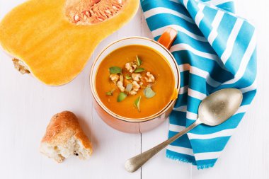 Pumpkin soup with bread and squash on white background clipart
