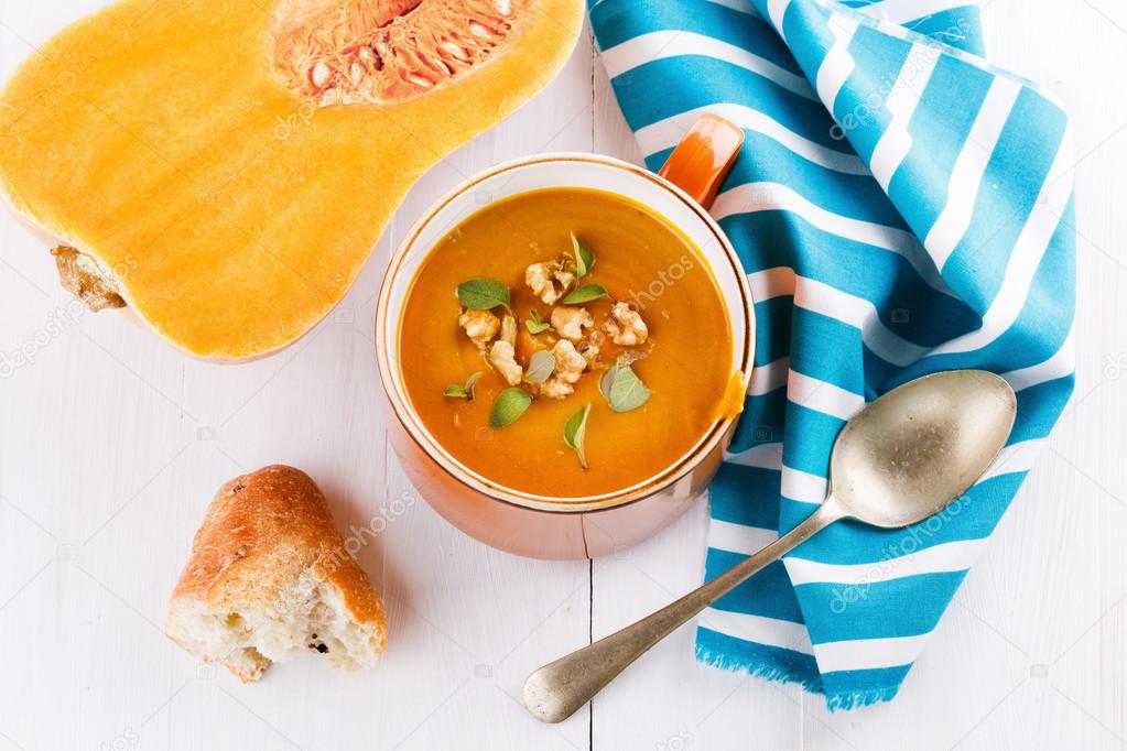 Pumpkin soup with bread and squash on white background