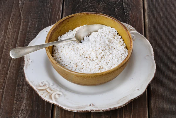 Beyaz pirinç rustik ahşap zemin üzerinde bir seramik kase — Stok fotoğraf